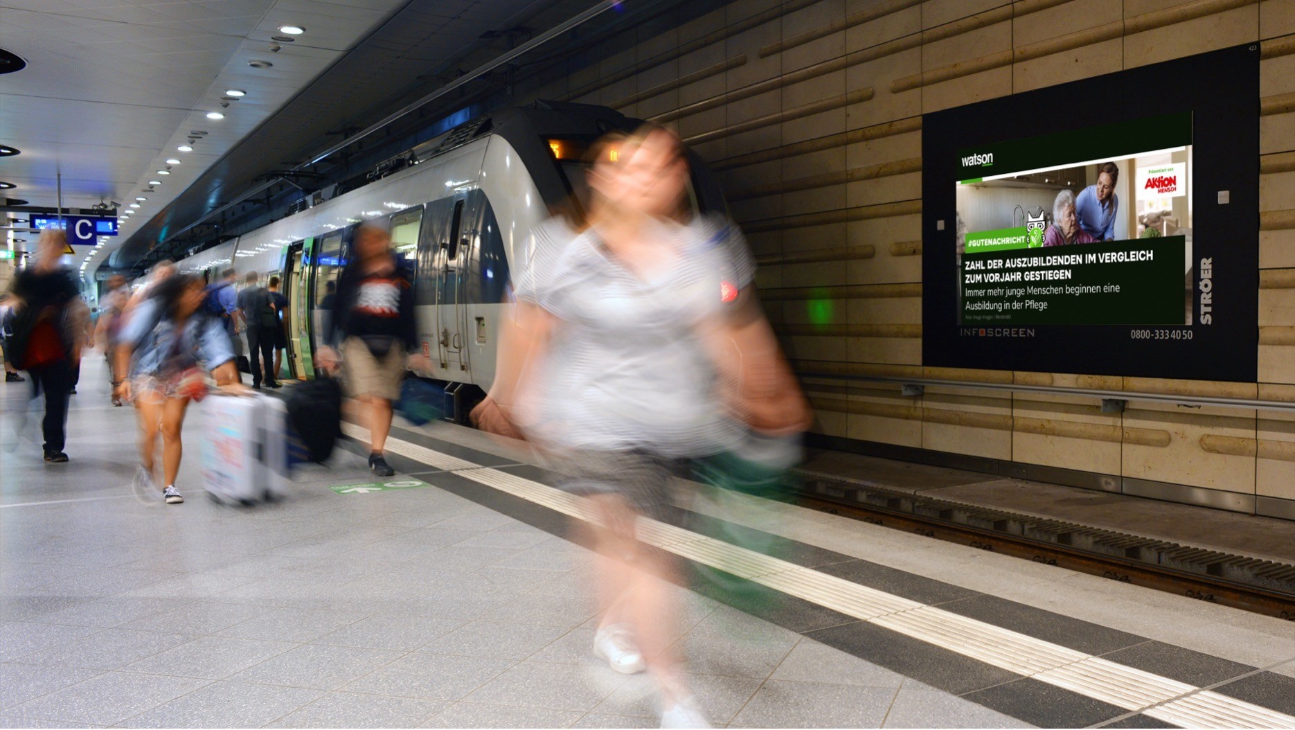 Digitale Out-of-Home-Werbung von Aktion Mensch und watson im InAd-Format auf Infoscreen am Bahnsteig – aufmerksamkeitsstarke Platzierung im Pendlerkontext.