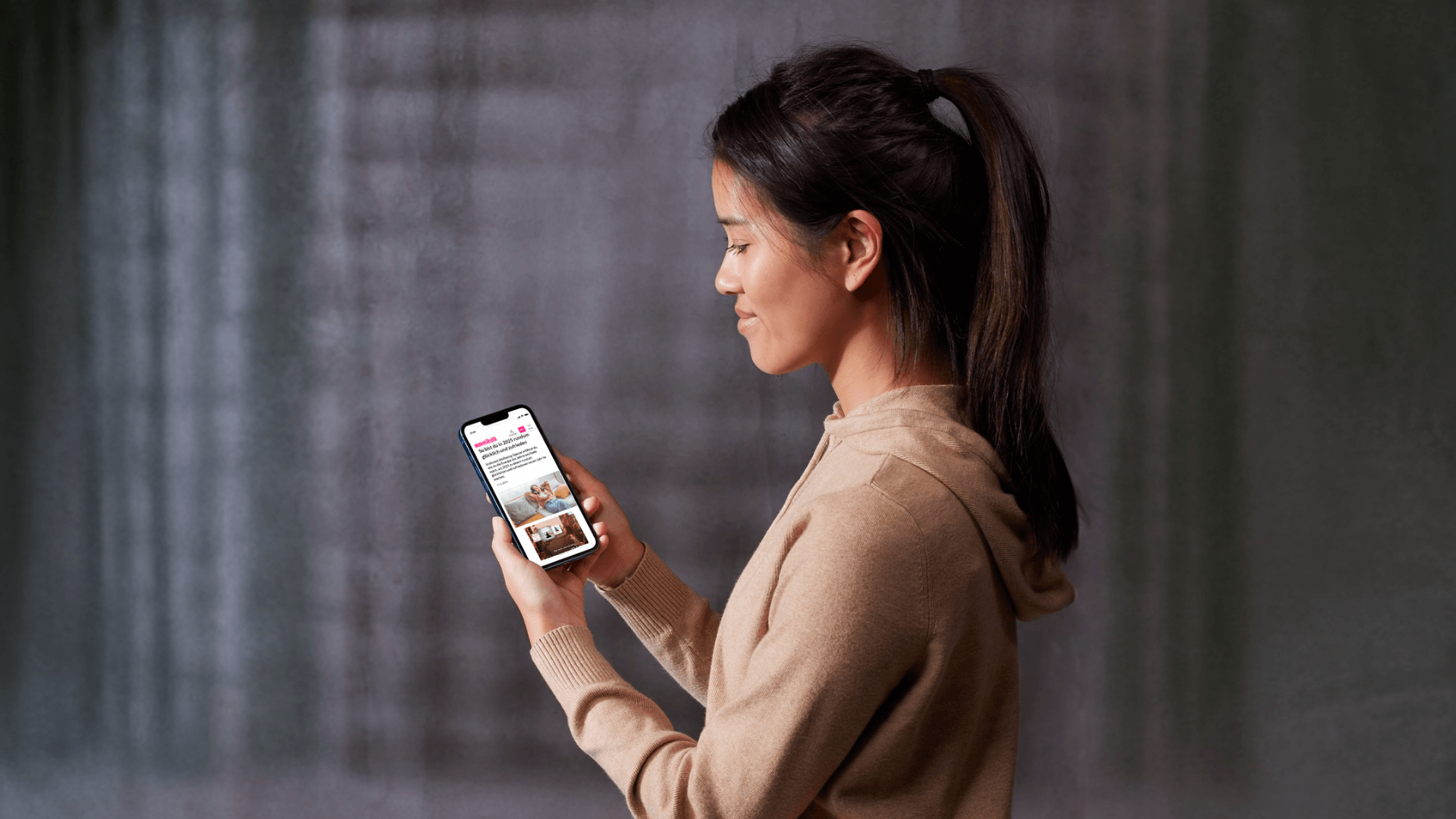Junge Frau betrachtet Native-Ad-Content auf dem Smartphone im Rahmen einer Audible-Wellness-Kampagne.