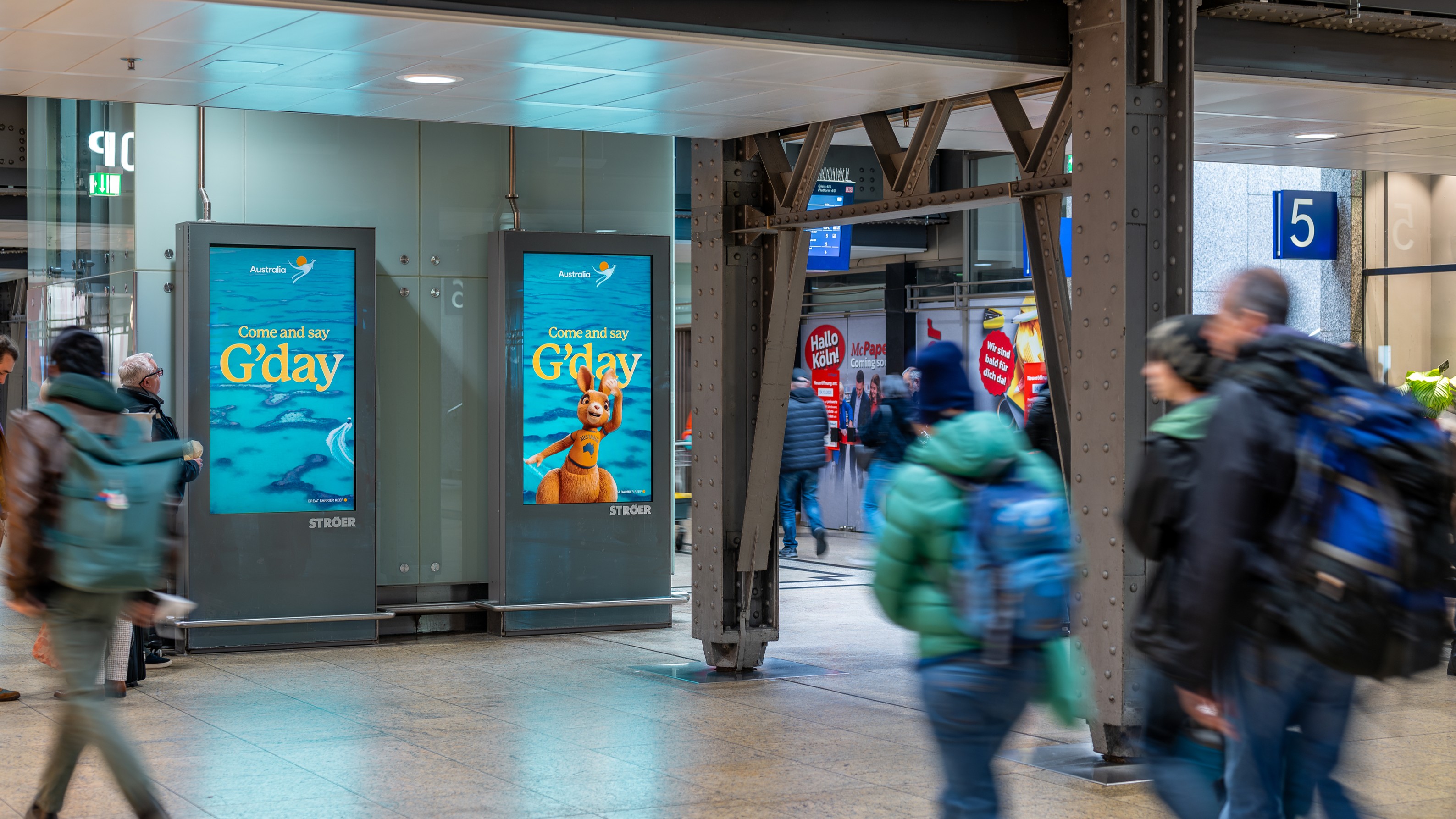DOOH-Werbeflächen von Tourism Australia in einer Bahnhofshalle, das Känguru-Motiv „Come and say G’day“ auf zwei nebeneinanderstehenden Screens.